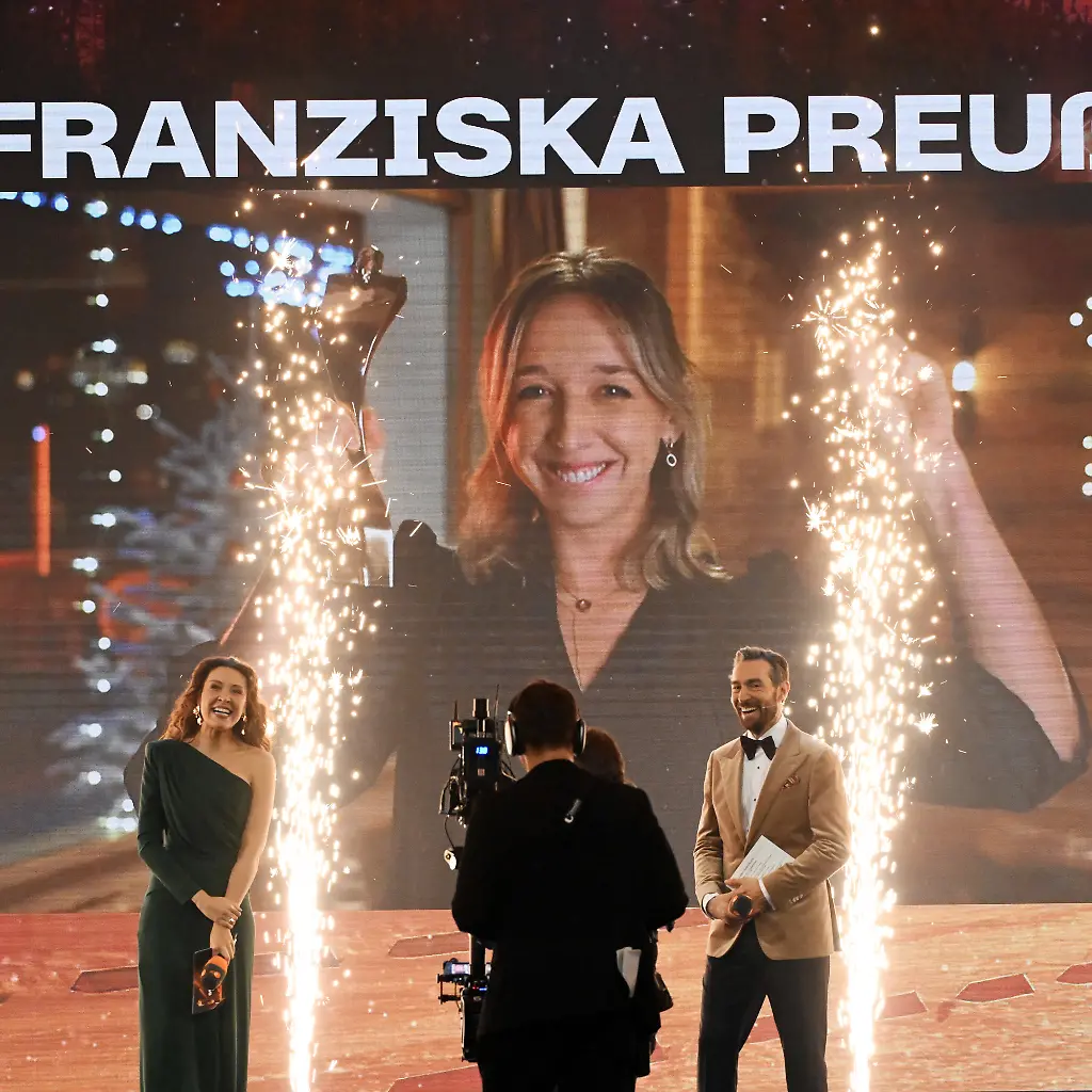 21-12-2025-Baden-Wuerttemberg-Baden-Baden-Die-Biathletin-Franziska-Preuss-wird-im-Kurhaus-Baden-Baden-bei-der-Gala-Sportler-des-Jahres-2025-als-Sportlerin-des-Jahres-2025-ausgezeichnet-Da-sich-Preuss-bei-einem-Wettkampf-befindet-wurde-sie-live-zugeschaltet-Im-Vordergrund-sind-die-Moderatoren-Lena-Kesting-und-Sven-Voss-zu-sehen