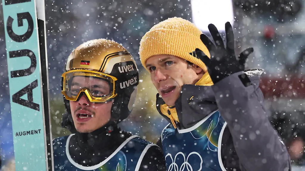 Olympia-Olympische-Winterspiele-Mailand-Cortina-2026-Ski-nordisch-Skispringen-Super-Team-Maenner-Finaldurchgang-Philipp-Raimund-l-Deutschland-reagiert-nach-seinem-Sprung-neben-Teamkollege-Andreas-Wellinger-Deutschland