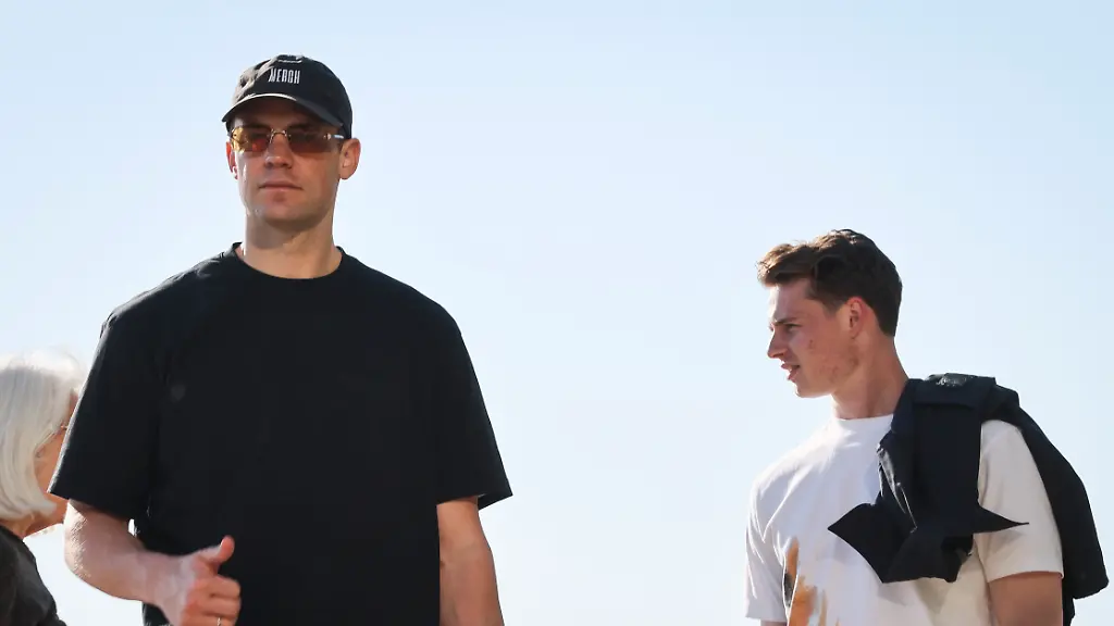Manuel-Neuer-l-und-Jonas-Urbig-r-beide-Torhueter-der-Fussball-Nationalmannschaft-gehen-am-fruehen-Morgen-auf-der-Promenade-am-Oak-Street-Beach-am-Lake-Michigan-entlang-Die-deutsche-Nationalmannschaft-ist-fuer-ein-kurzes-Trainingslager-vor-dem-Start-der-Fussball-Weltmeisterschaft-in-Chicago-angekommen-und-reist-nach-einem-Testspiel-am-6-Juni-gegen-die-USA-in-ihr-WM-Basislager-nach-Winston-Salem