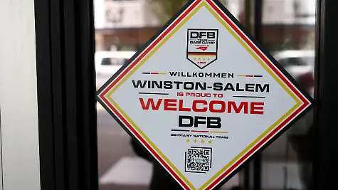 Ein-Aufkleber-auf-der-Tuer-zu-einem-Cafe-heisst-die-Deutsche-Nationalmannschaft-willkommen-Am-Montag-08-06-wird-die-Deutsche-Nationalmannschaft-ihr-Mannschaftsquartier-fuer-die-Vorrunde-in-der-Stadt-beziehen