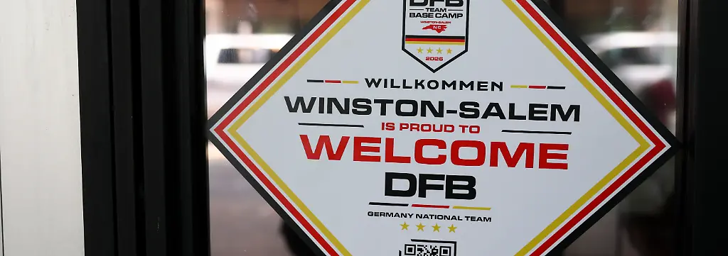 Ein-Aufkleber-auf-der-Tuer-zu-einem-Cafe-heisst-die-Deutsche-Nationalmannschaft-willkommen-Am-Montag-08-06-wird-die-Deutsche-Nationalmannschaft-ihr-Mannschaftsquartier-fuer-die-Vorrunde-in-der-Stadt-beziehen