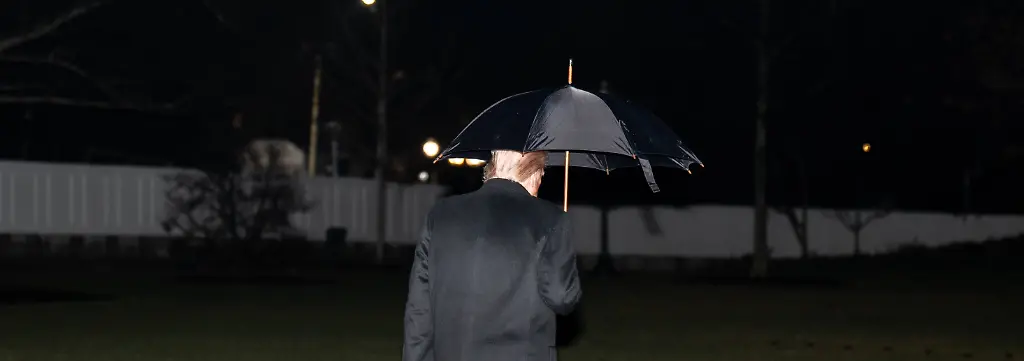 January-9-2026-Washington-District-Of-Columbia-USA-President-DONALD-TRUMP-walks-across-the-South-Lawn-of-the-White-House-to-Marine-One-while-holding-an-umbrella