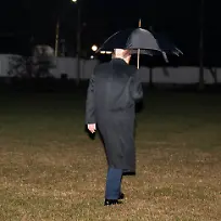 January-9-2026-Washington-District-Of-Columbia-USA-President-DONALD-TRUMP-walks-across-the-South-Lawn-of-the-White-House-to-Marine-One-while-holding-an-umbrella