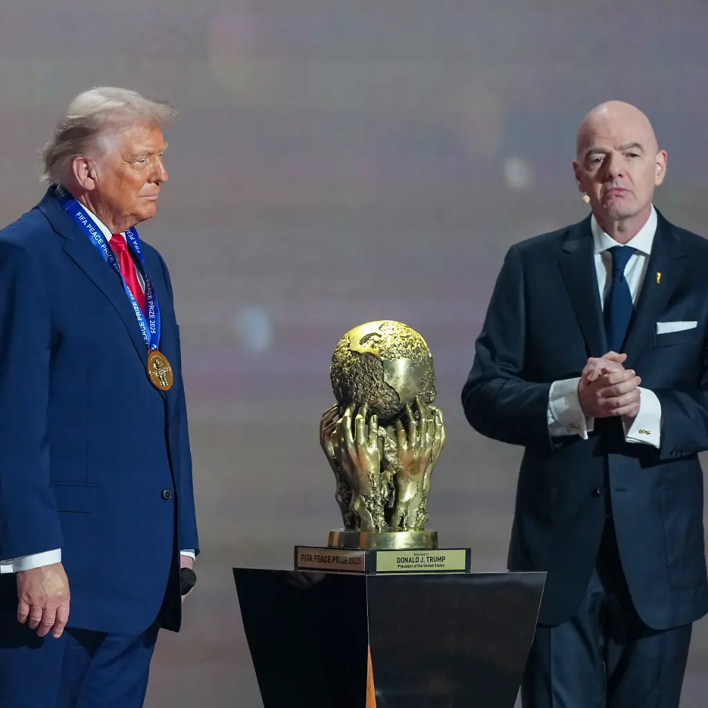 L-R-US-President-Donald-Trump-looks-on-as-he-receives-the-FIFA-Peace-Prize-from-FIFA-President-Gianni-Infantino-during-the-draw-for-the-2026-FIFA-Football-World-Cup-taking-place-in-the-US-Canada-and-Mexico-at-the-Kennedy-Center-in-Washington-DC-on-December-5-2025