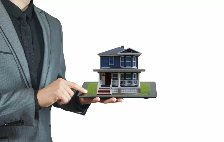 Ein Mann zeigt eine zum Verkauf stehende Immobilie. In diesem Artikel erklären wir alles über eine Immobilienmakler-Website.