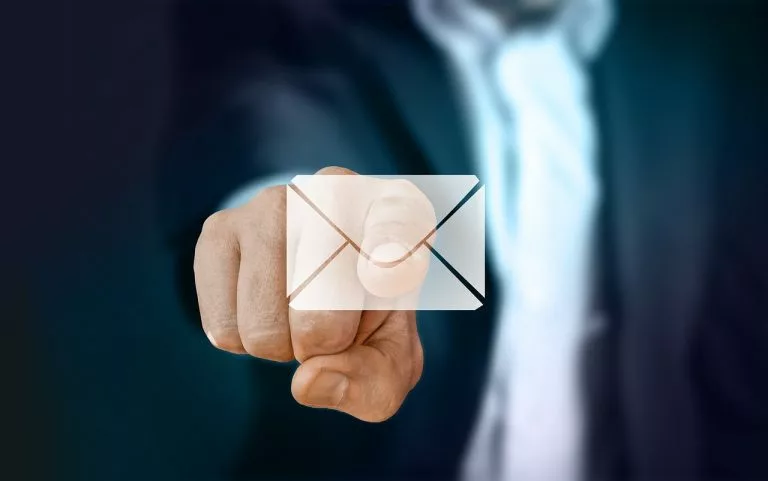 eine Person drückt eine Taste mit einem E-Mail-Symbol