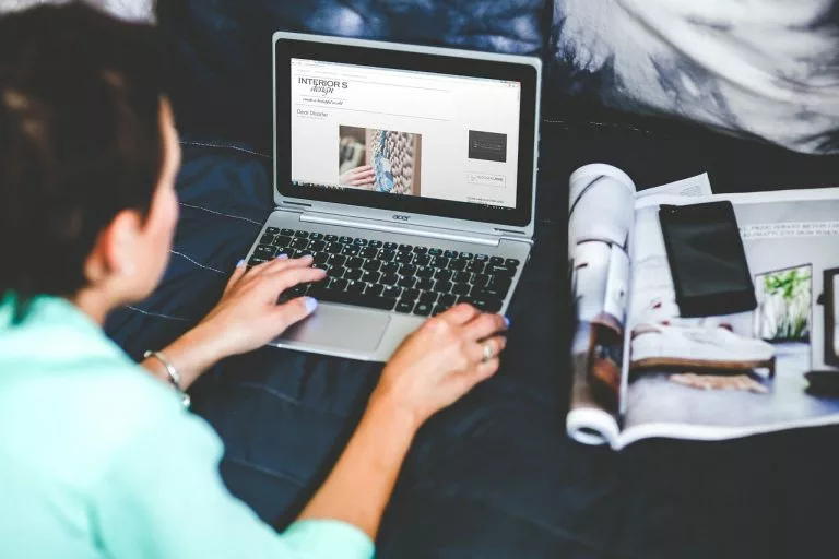 Eine Frau schreibt einen Blog auf einem Laptop.